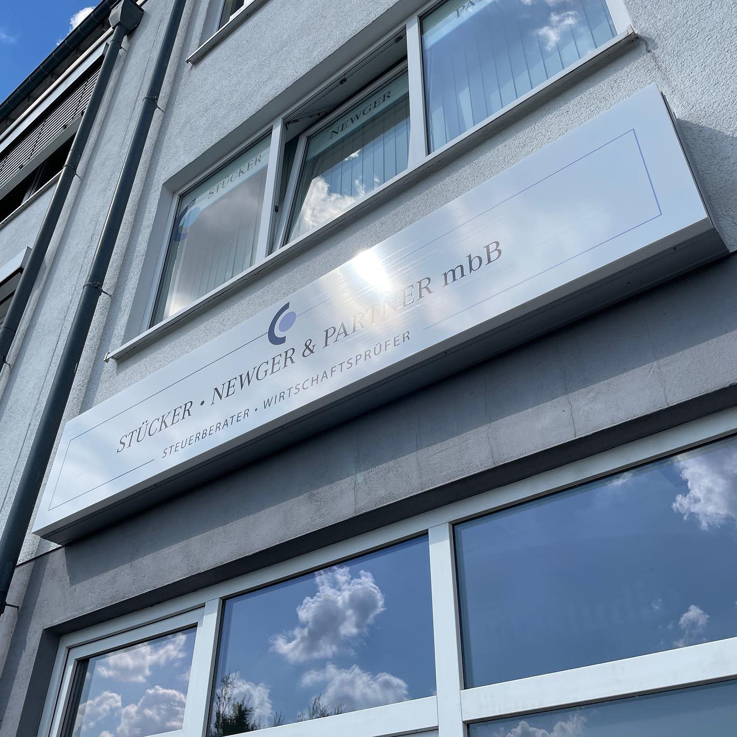 Beleuchtetes Firmenschild an einer Fassade in NRW, umgesetzt von ComTwo